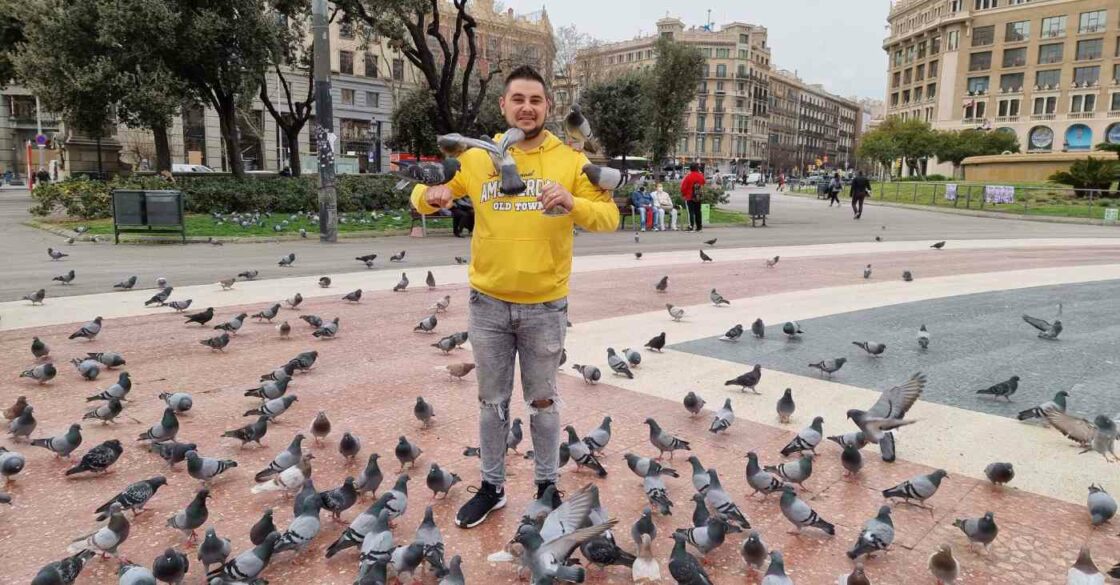 RE/MAX Makler Catalin Ruiu am Plaça de Catalunya beim Tauben füttern.