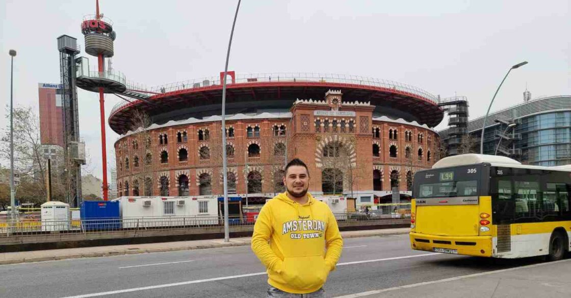 RE/MAX Makler Catalin Ruiu in Barcelona mit dem Gebäude Arenas de Barcelona im Hintergrund.